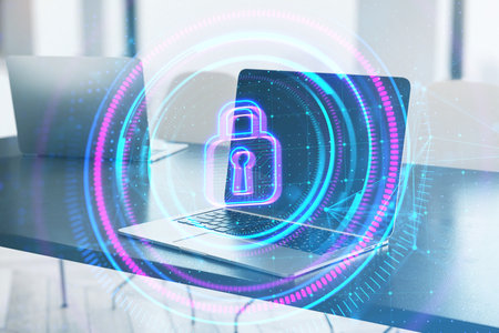 Close up of laptop on desktop with digital round polygonal padlock button on blurry background....