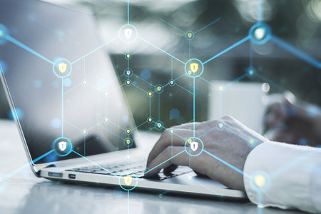 Close up of male hands using laptop with creative glowing hexagonal pattern with tiny padlocks on...
