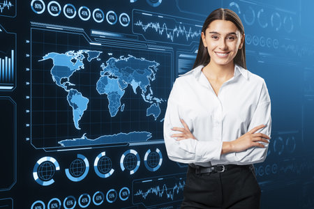 Attractive smiling businesswoman with folded arms and glowing digital business charts and map interface on blurry background. Military control, warfare and spy conceptの写真素材