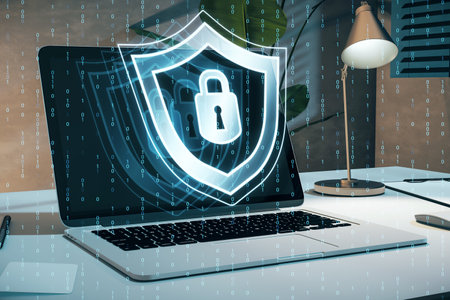 Close up of laptop at workplace with creative digital security padlock and shield hologram on blurry binary code background. Secure, safety and identification concept. 3D Renderingの写真素材