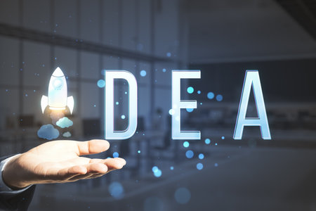 Close up of man hand holding creative text with space ship replacing letter on blurry office interior background with bokeh circles. Think, idea, start up, creative and inspire conceptの写真素材