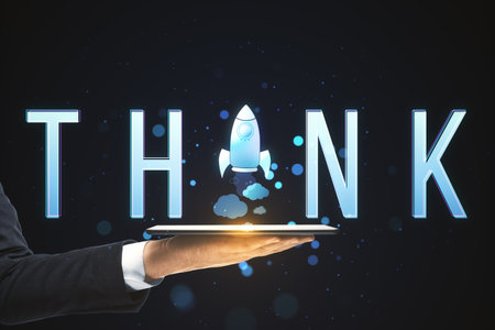 Close up of businessman hand holding tablet with creative text with space ship replacing letter on blurry background with bokeh circles. Think, idea, start up, creative and inspire conceptの写真素材