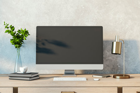 Contemporary designer desktop with empty computer monitor, lamp, supplies and other items. Concrete wall background. Mock up, 3D Renderingの写真素材