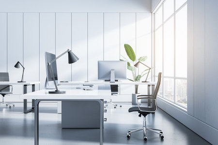 Sunny office interior with white desks, computers, and panoramic city view. Productive environment. 3D Renderingの写真素材
