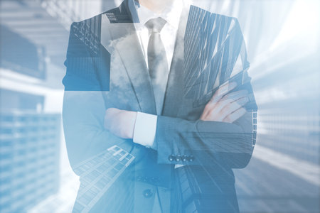 Double exposure image of a businessman overlapping with cityscape, depicting corporate life and urban developmentの写真素材