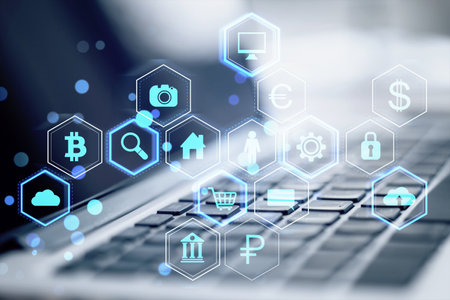 Close up of laptop keyboard on desk with abstract hexagonal pattern hologram with various business icons on blurry background. Digital dashboard and data concept. Double exposureの写真素材