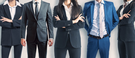 A group of five corporate professionals in suits standing confidently with arms crossed It represents teamwork and leadershipの写真素材