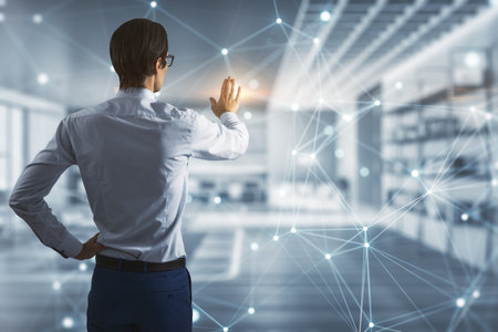 Modern office setting with male professional interacting with futuristic holographic screen interface, concept of technology in businessの写真素材