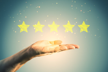 Close up of male hand holding 5 star rating on blurry background. Customer service and excellent...