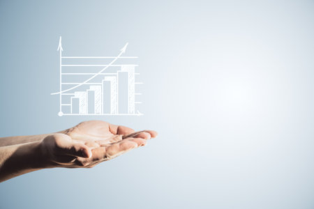 Close up of male hands holding white growing business chart on light background with mock up place. Ad, financial growth and marketing conceptの写真素材