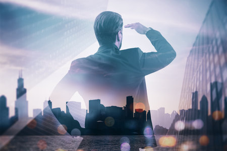 Back view of young man standing on blurry airy city background with mock up place. Future, tomorrow and success concept. Double exposureの写真素材