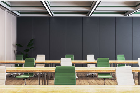 A modern classroom interior with rows of empty green and white chairs, wooden desks, and a...