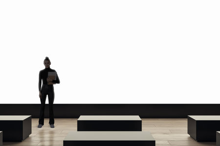 Empty cinema screen with a person holding a notebook standing in front of it, modern interior with black and wooden elements, concept of presentation or movie screeningの写真素材