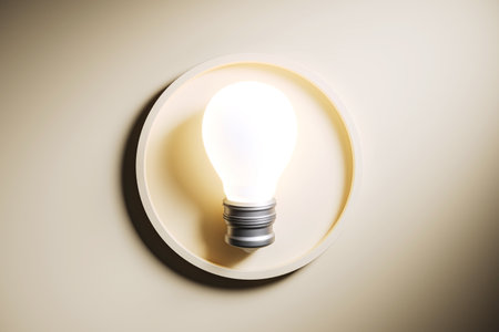 Glowing light bulb mounted on a matte wall background, symbolizing a bright idea or innovation. Minimalist design, business concept. 3D Renderingの写真素材