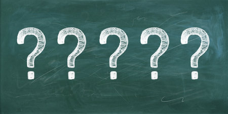 Five question marks drawn with white chalk on a green blackboard. Symbolizes confusion, questions, choices, or education concept. Background of a classroom or educational settingの写真素材