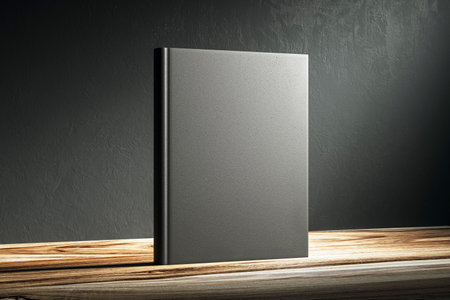 Hardcover book mockup standing on a wooden table against a dark background under a spotlight, perfect for presentations and branding designs. 3D Renderingの写真素材