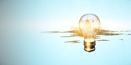 glowing light bulb on abstract weathered city on light background with mock up place. Innovation, idea and inspiration concept.の写真素材