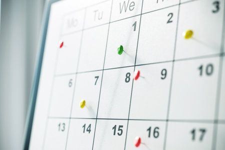 Closeup of a calendar with colorful pins marking important dates, emphasizing event planning and time management on a blurred background. 3D Rendering.の写真素材