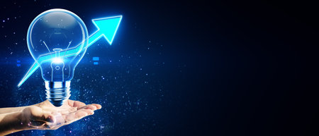 Lightbulb with upward arrow held in hands, glowing on dark background. Represents the concept of growth, innovation, and success in businessの写真素材