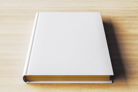 Closeup of a clean, white hardcover book mockup lying on a light wooden table. Ideal for presentation, branding, or design concepts. 3D Renderingの写真素材