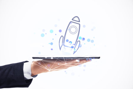 Businessman's hand holding a tablet with a digital rocket launch illustration. Clean and white...