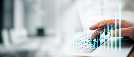 Closeup of a person typing on a laptop keyboard with financial graphs overlayed, in a modern office...