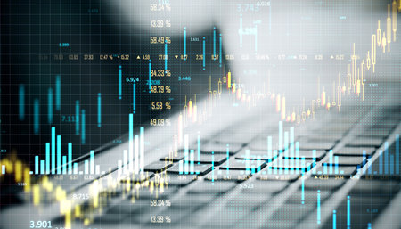 Double exposure image featuring financial charts and graphs superimposed over a keyboard background, symbolizing data analysis and market trendsの写真素材