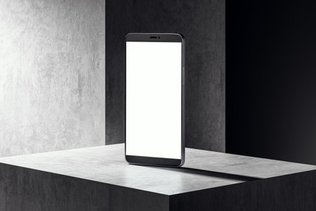 Modern smartphone with a blank screen standing on a grey pedestal. Dark concrete background. Concept of technology and design. 3D Renderingの写真素材