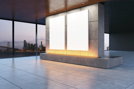 Modern gallery room with two blank posters on a concrete wall, illuminated by subtle lighting. City skyline visible through large windows at dusk. 3D Renderingの写真素材