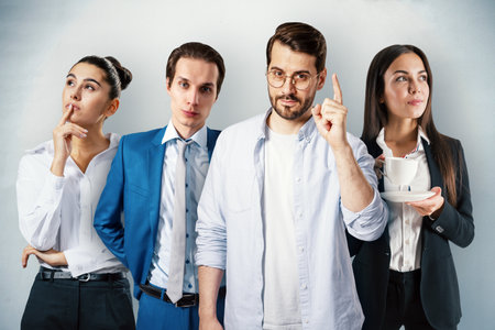 Group of four businesspeople brainstorming and discussing ideas in an office interior. Corporate teamwork and collaboration conceptの写真素材