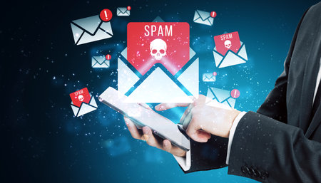 Image showing a person using a tablet, surrounded by spam email icons with skulls on a digital background. Concept of cybersecurity threatsの写真素材
