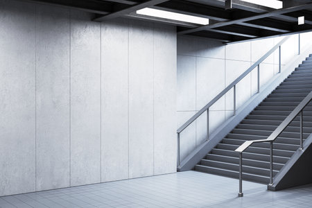 Empty modern subway station with a large blank wall and staircase, grey concrete background, concept of advertising and branding template. 3D Rendering.の写真素材