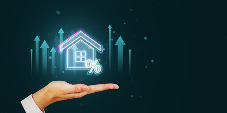 A hand holds a glowing house and percent sign, with arrows pointing upward. The background is dark, representing digital mortgage technology conceptの写真素材