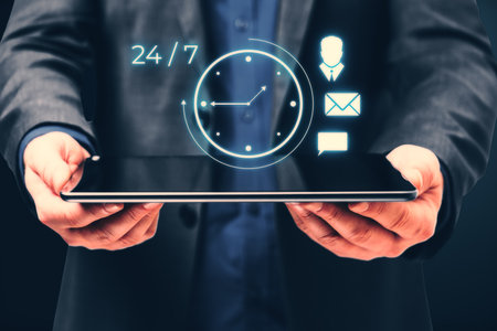 A businessman holds a tablet with holographic icons of a clock, person, email, and chat. Dark...