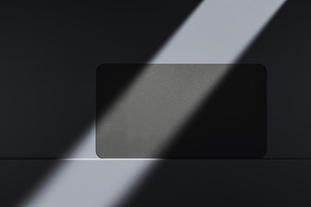 Close up of clean black business card on dark desk surface with sunlight. Ad concept. Mock up, 3D Renderingの写真素材