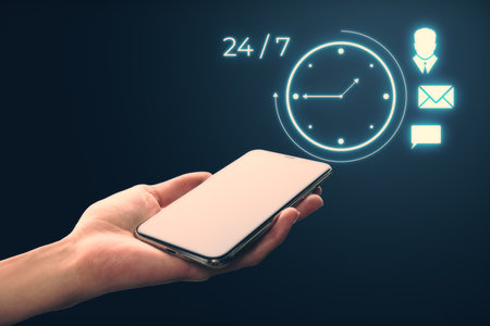 A hand holding a smartphone with holographic icons representing 24 7 time, messaging, tasks, and a...