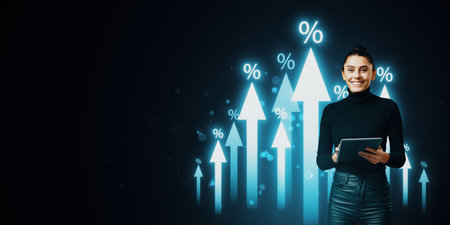 Attractive smiling European businesswoman with tablet and growing glowing interest arrows hologram on dark background with mock up place. Benefit, market and increase conceptの写真素材