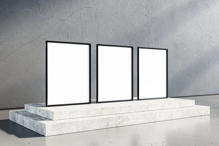 Three blank framed displays on a stone podium in a modern concrete interior. Creative space concept...
