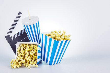 Popcorn in blue-striped containers with a soda cup and movie clapper, isolated on light gradient background. Concept of cinema and movie nights. 3D Renderingの写真素材