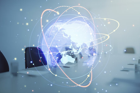 Abstract digital globe overlayed with light trails and particle effects, placed over an office setup, concept of global communicationの写真素材