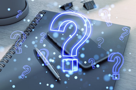 Notebook, phone, and pen on a desk with glowing holographic question marks overlaid, creating a futuristic technology conceptの写真素材