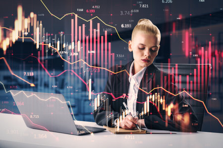 Woman in office with a laptop and financial data overlay, examining market trends. Double exposure...