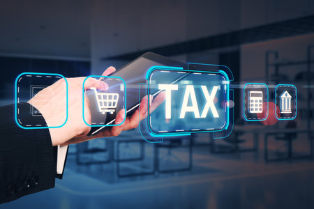 Businessman using a tablet with glowing tax-related icons on a blurred office background, symbolizing online tax services and digital economyの写真素材