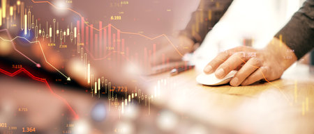 Financial charts and candlestick graphs overlayed on a blurred background with a hand using a computer mouse, symbolizing stock market analysisの写真素材