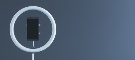 Smartphone mounted in a ring light holder on a gradient background, showcasing a professional setup for content creation or live streaming. 3D Rendering.の写真素材
