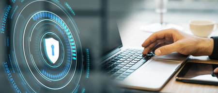 Shield icon on a glowing holographic interface with a person's hand on a laptop keyboard. Modern...