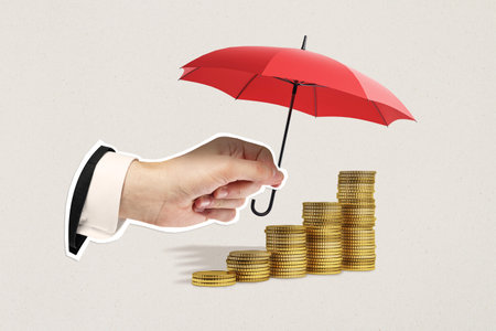 Hand holding red umbrella shielding stacked gold coins on beige background. Concept of financial protection, growth, and successの写真素材