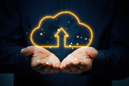 Hands presenting glowing cloud icon with an upload arrow, dark background. Concept of cloud...