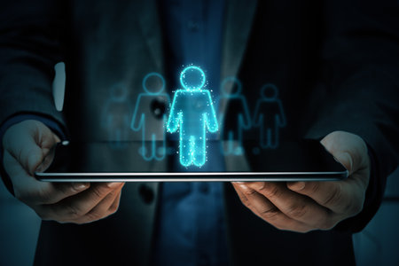 Businessman holding tablet with neon hologram icon of man on dark background. Concept of technology, digital, businessの写真素材