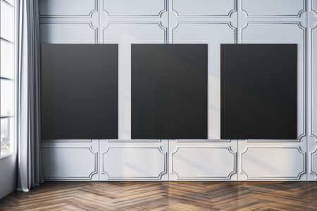 Three black blank posters on a white paneled wall in a modern gallery room with wooden flooring and natural light from a large window. 3D Rendering.の写真素材